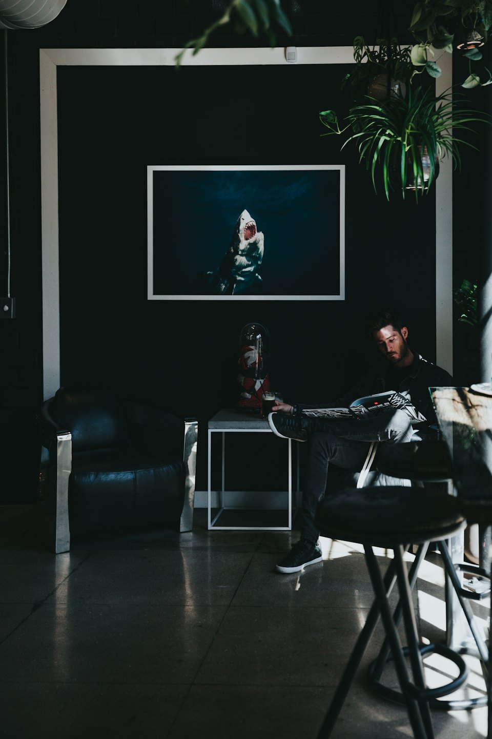 Hombre leyendo una revista en un salón moderno.